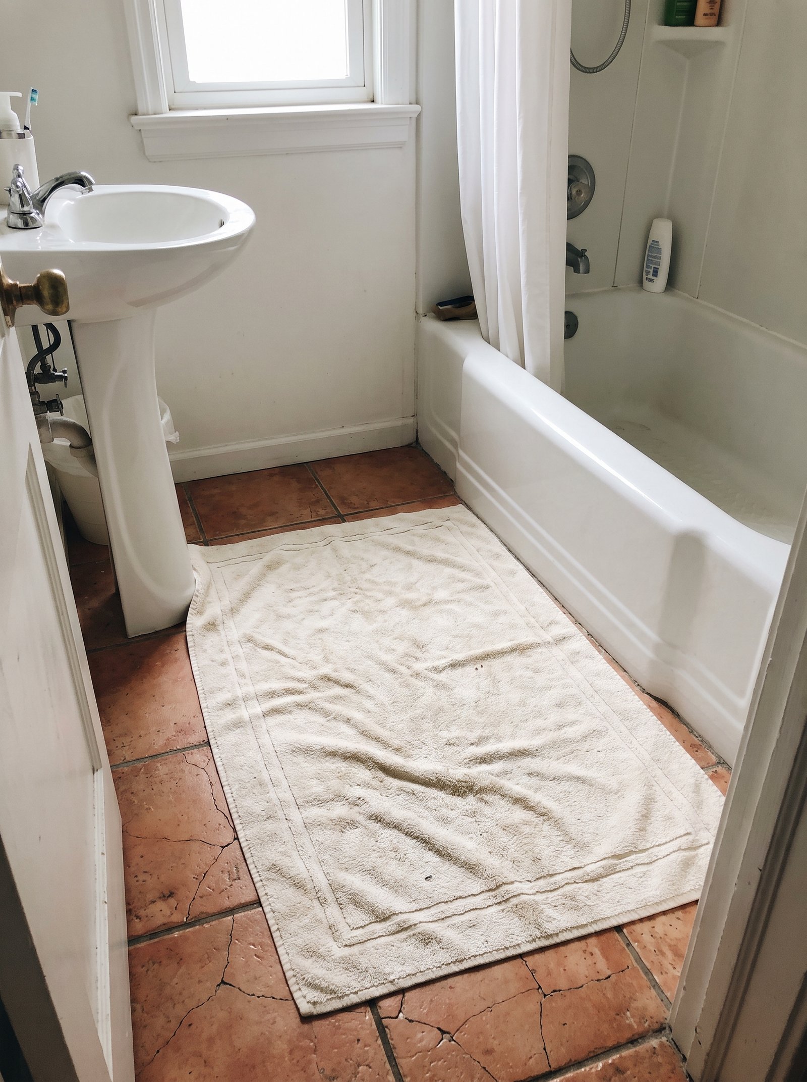 Buy an oversized bath mat that hides more floor